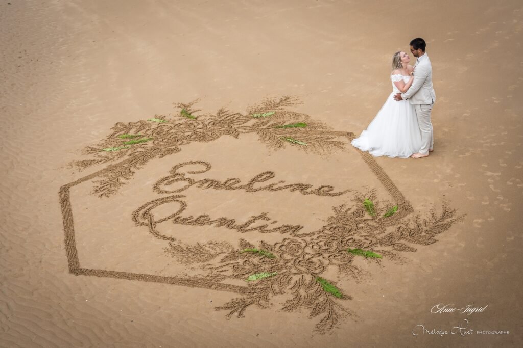 Dessin dans le sable avec jeunes mariés